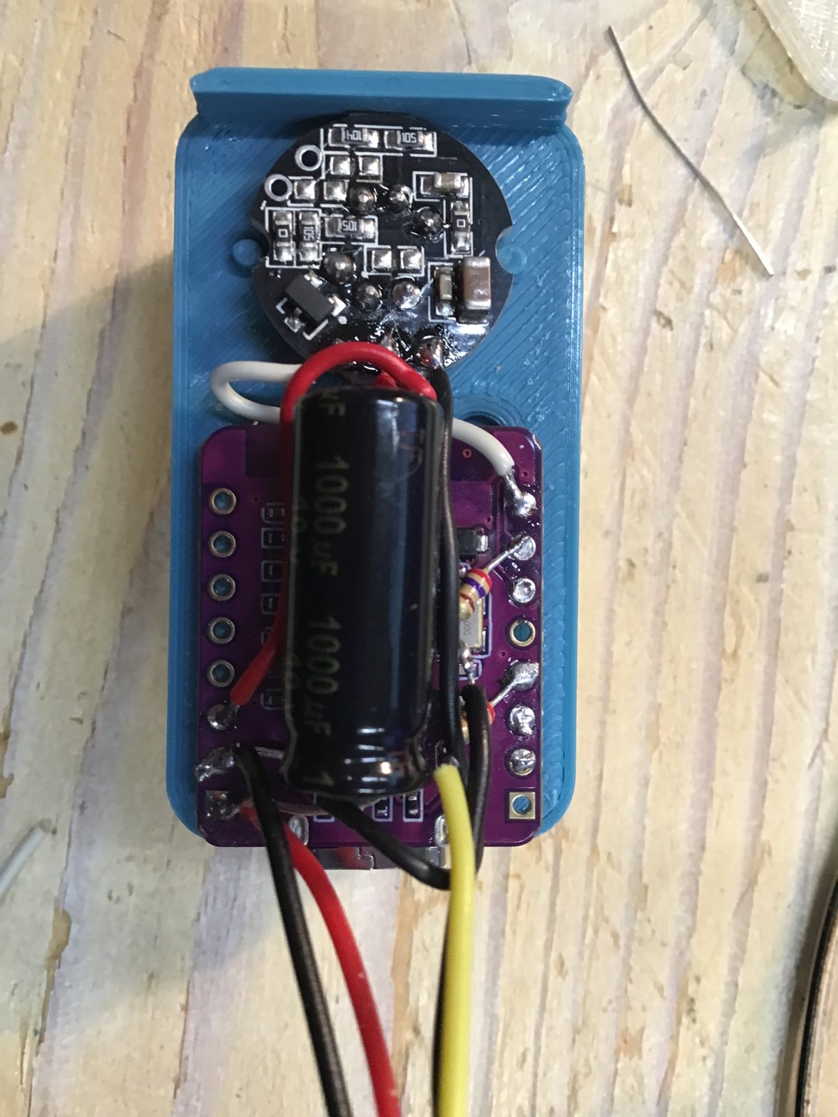 Binnenkant van het deksel: de sensor bovenin, het paarse bordje met de condensator en de draadjes.